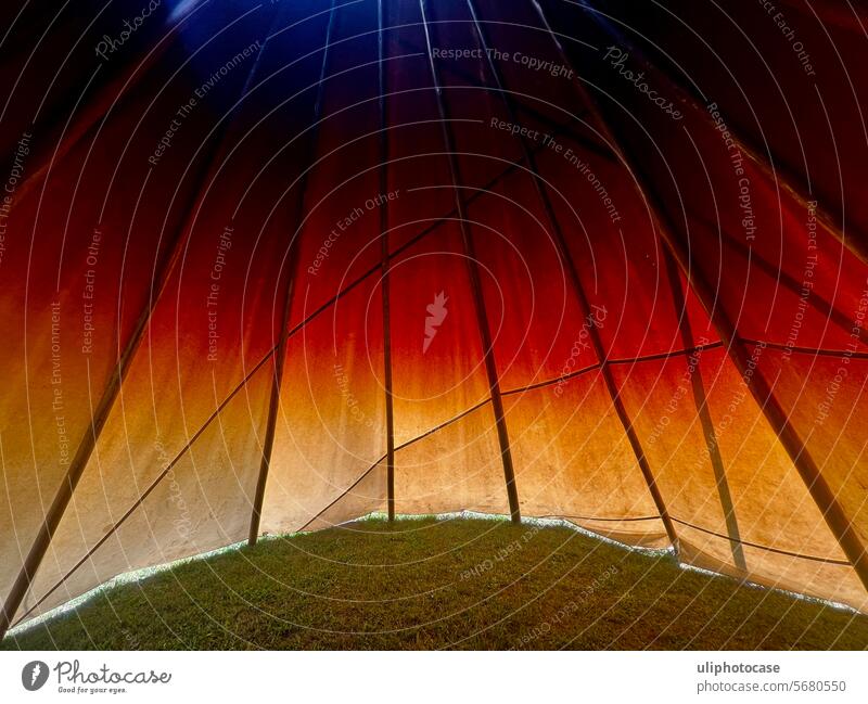 Colored tipi tent wall from the inside in the light of the sunset Tee Pee Play of colours Canvas Back-light Picturesque Tent from the inside