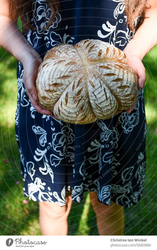 a beautifully decorated bread in the hands of a young woman Bread loaf Woman To hold on Self-made Food Fresh Tasty Crust Nutrition baked Delicious Rustic Wheat