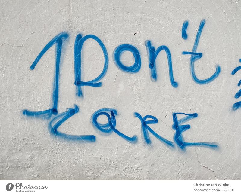 I don't care / blue lettering on a white house facade no matter Daub Graffito Frustration frustrated Aggravation resignation Emotions Characters Text Typography