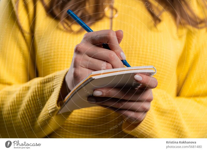 Woman writing notes in planner with pen. Girl thinking future plans, to-do list adult analyzing asian blue book caucasian college communication concentrating