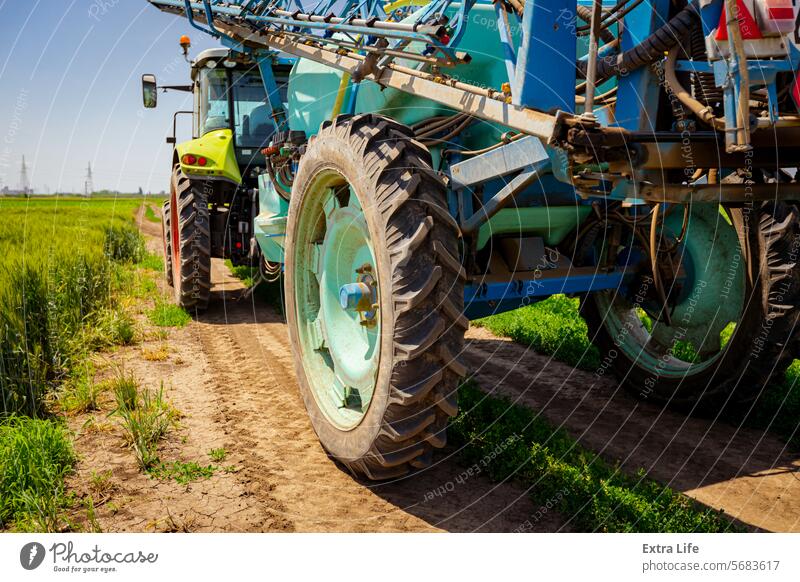 Low view of tractor with mounted sprayer as travel on dirty road Aerosol Agricultural Agriculture Biochemical Care Cereal Chemical Country Crop Dirty Drag Drive