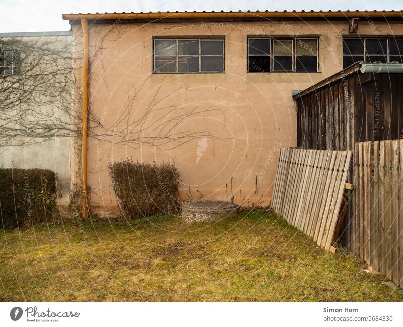 Grass area in a backyard, surrounded by exterior walls and fence elements Backyard lawn Fence Fence elements Workshop Hall tidied Still Life Old Window Building