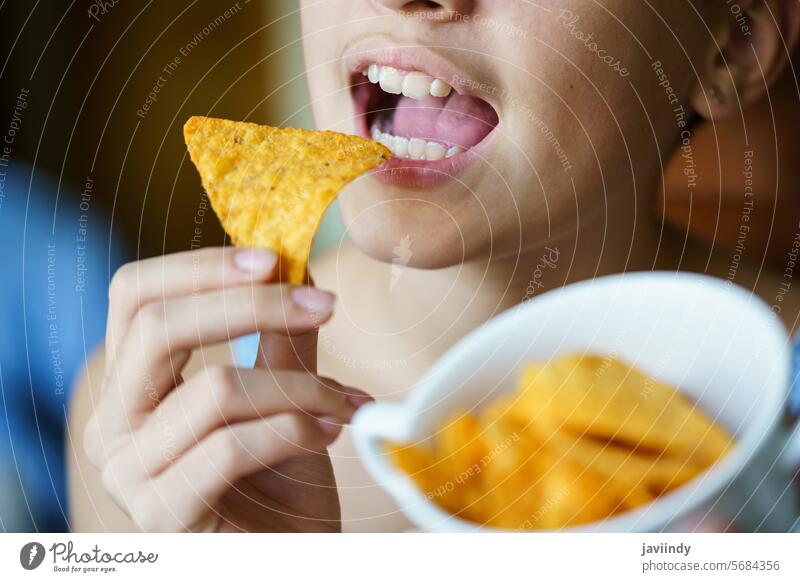 Unrecognizable girl about to eat spicy tortilla chip at home Girl Mouth Open Nachos Eat Crispy Delicious Unhealthy Tortilla Chip Snack Food Mexican Fried Spicy