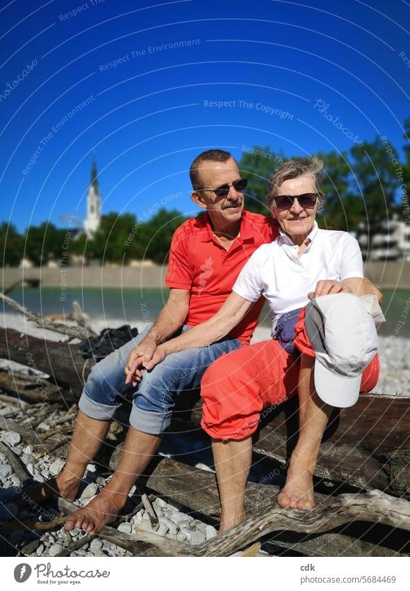 typical german | tourism | happy senior couple taking a break at the beautiful Isar river near Bad Tölz senior citizens Couple people Senior citizen Retirement