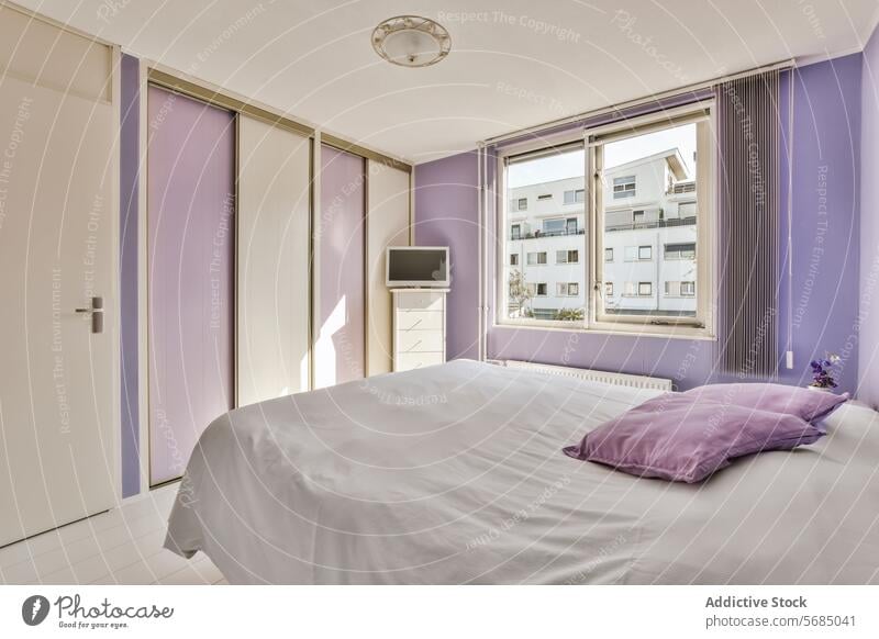 Modern bedroom with purple accents and city view contemporary modern wall drapes urban apartment interior design home pillow furniture white bedding window