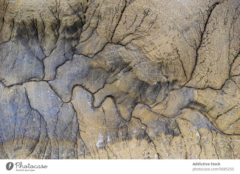 Aerial image of a dried riverbed with deep erosion patterns and cracks in the desert of Utah, showcasing dramatic earth textures USA landscape natural