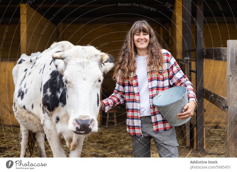 Happy farmer woman with a dairy cow on a rural farm adult agriculture animal barn business calf care caress cattle caucasian cheerful confidence countryside