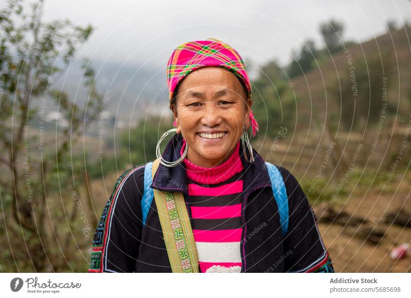 Happy middle aged ethnic woman standing in countryside smile rural hill tree building happy cheerful nature female mature asian vietnam headscarf vietnamese