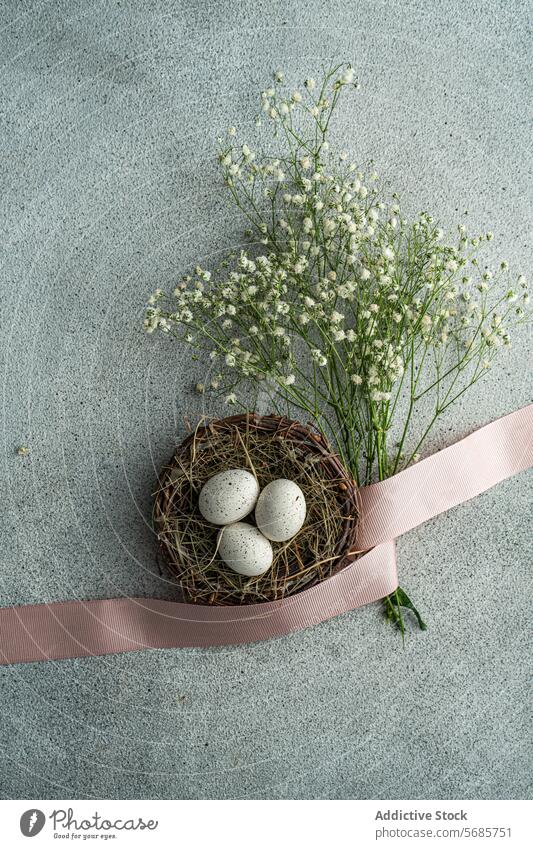 Elegant Easter eggs and flowers on textured background easter speckled basket ribbon pink white rustic arrangement delicate top-down nest gray spring