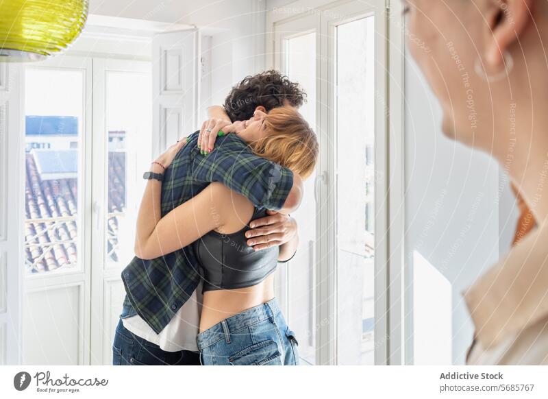 Happy couple hugging each other at home embrace happy smile apartment casual outfit fondness bonding stand lady male female light guy wife romantic adult jeans