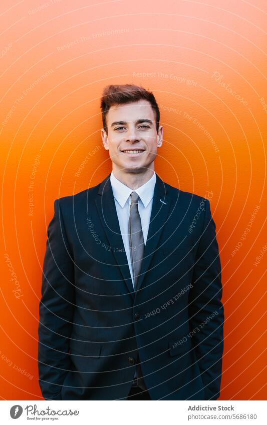 Confident businessman looking at camera posing against orange backdrop suit smile wall young male professional confident vibrant madrid spain portrait fashion