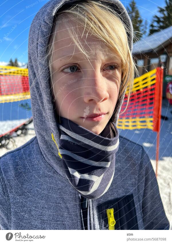 Boy taking a break from skiing Ski piste Catching net Snow portrait Meditative dreamily Sun Mountain Winter Vacation & Travel Skiing Winter sports