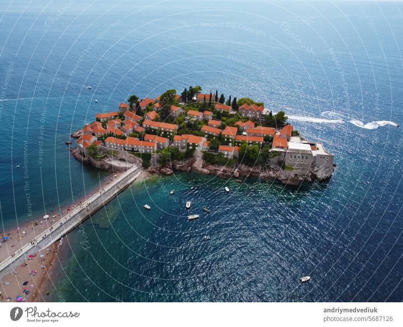 Aerial view of Sveti Stefan island and shore in a beautiful summer day, Montenegro from flying drone. Panoramic above view of Saint Stephen luxury resort. Tourism and leisure concept. Aero photography