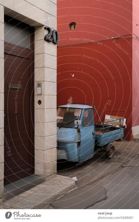 Light blue Ape tricycle in the backyard in front of a red house wall Vehicle ape Tricycle Italy moped Characteristic Cliche Simple Deserted Authentic Old shabby