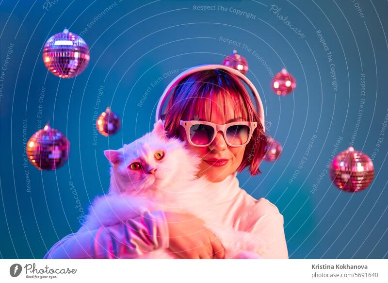 Disco woman with cat listening music with headphones, on studio background dance disco enjoy female lady young caucasian dj earphones entertainment girl party
