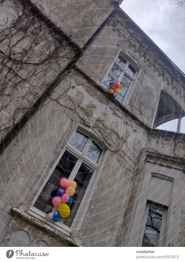 Colorful balloons attached to two windows of an old building from the Wilhelminian era. variegated refurbishment of an old building Old building Gentrification