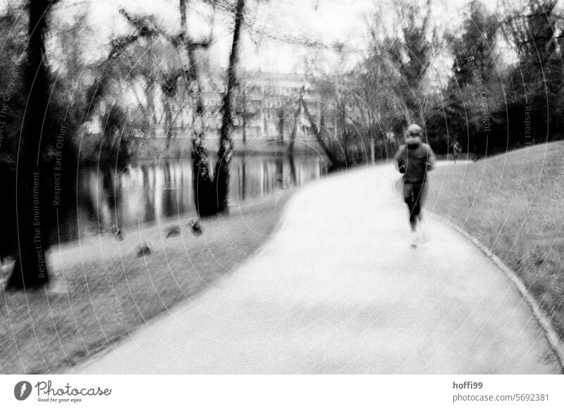 Moving camera behind a jogger in motion in the park Jogging Joggers motion blur Pursue Park Bad weather Sports Runner Fitness Walking Healthy workout Lifestyle