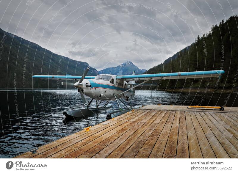 A floatplane in the fjords of Alaska at the pier alaska travel airplane transportation aircraft vacation sea tourism seaplane water aviation fly nature