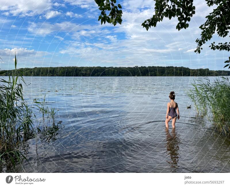 Girl runs into a lake for a swim Summer Summer vacation Summery Swimsuit Child Infancy Lake Lakeside bathe Beach vacation reed Common Reed standing Water