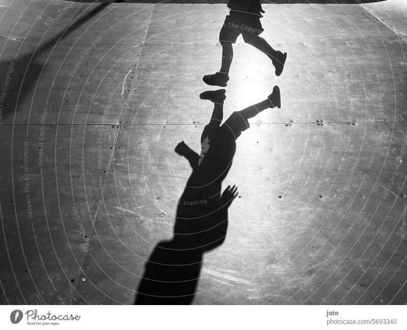Silhouette of a child running and playing on a skating rink Silhouette people Silhouette photography Shadow Shadow play shadow cast Shadow image children