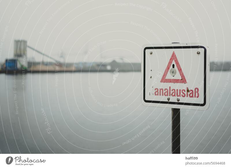 misused sign for an anal outlet in the harbor with a foggy backdrop Signage ambiguous Production Anal outlet Channel alienated alienation creative design