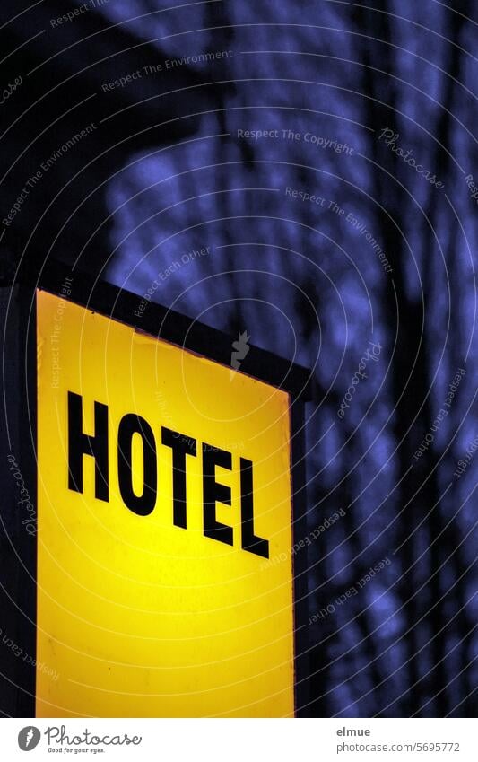 yellow illuminated sign HOTEL in the late twilight Hotel Neon sign overnight Room booking Accommodation service publicity advertising sign Signs and labeling