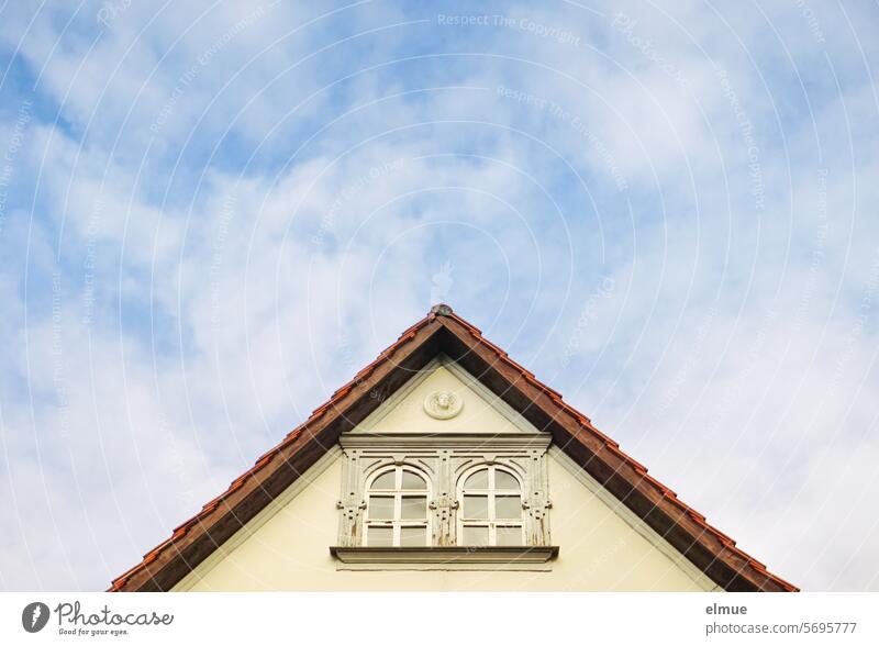 Gable wall with two decorated windows against a blue sky pediment house gables Window Tiled roof decoration gable wall Decorative ornaments Window decoration