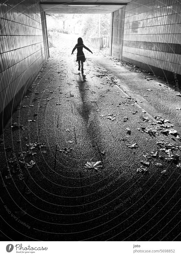 Silhouette of a child running playfully through a tunnel Silhouette people Silhouette photography Shadow play shadow cast Shadow image children Running Child