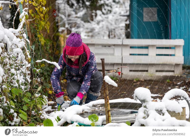 Woman working on her allotment in winter snow cold weather Gardening Equipment Leisure Activity Lifestyles back yard Day Outdoors nature garden community garden