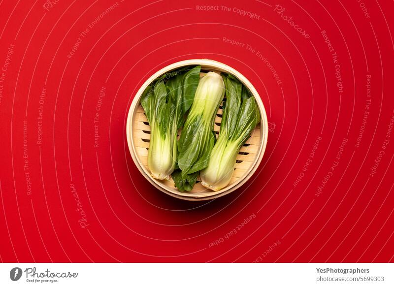 Bok choy cooked in bamboo steamer, above view on a red table asian background basket blank bright cabbage chinese color cooking copy space cuisine cut out