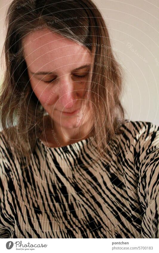 a woman with her head bowed and her eyes closed. come to rest Woman Stress close one's eyes lowered head Resign give up meditate ponder zebra pattern gray hair