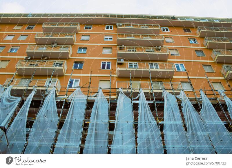 Residential building with scaffolding and safety net, partially renovated. Construction site Apartment Building residential building Scaffolding