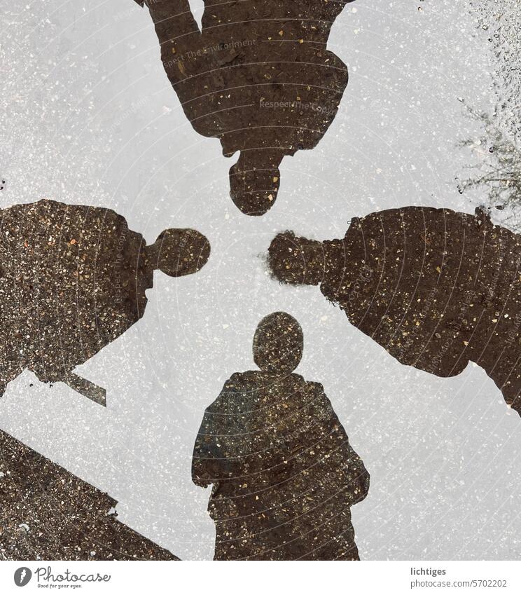 Four-fold shadow of four people in a puddle Shadow Rain reflection game Contrast