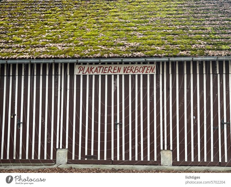 Wall on an old wooden house on which it is forbidden to put up posters, painted by hand Effective messages Placard Wooden wall moss roof Retro Arrangement