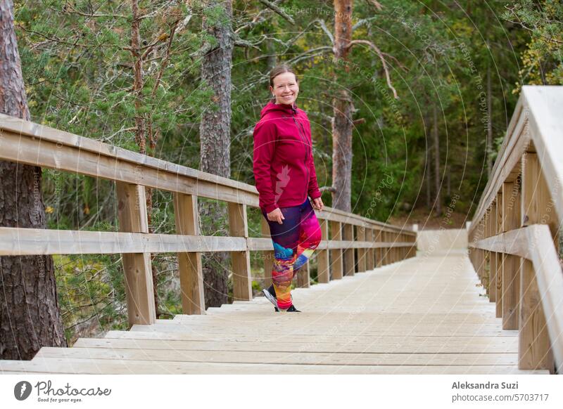 Athletic middle-aged woman running up the Fitness Stairs in a natural park in the woods active activity alone athlete athletic cardio caucasian challenge cold