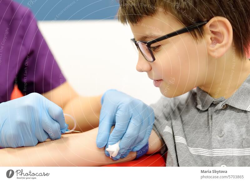 A nurse takes blood from a child. Close up video of a boy's hand while taking a blood sample for examination in a modern laboratory or hospital. needle test kid