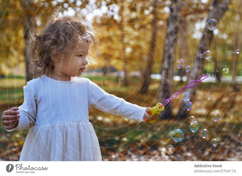 Ethnic child playing with bubbles in a Californian park outdoor fun joy toddler ethnic diversity california nature sunlight autumn tree innocence leisure