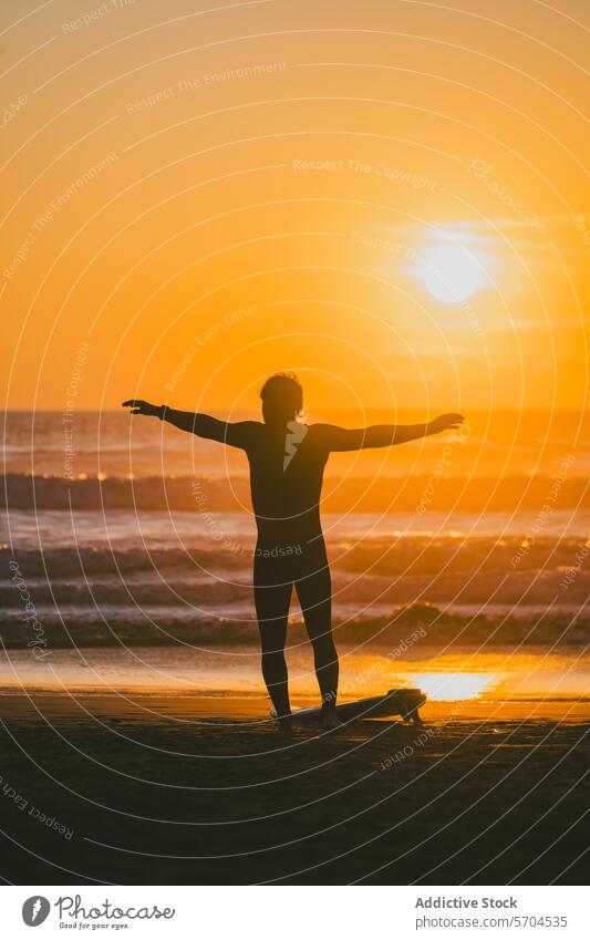Male surfer with arms spread standing on beach with surfboard at sunset man sea silhouette water wave nature sand shore ocean coast male sundown harmony hobby