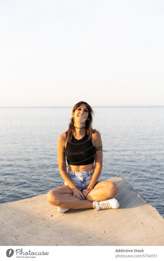 Young woman sitting on pier near sea water smile trip fresh happy enjoy tourist ocean pleasure positive natural ripple glad coast marine energy pleasant