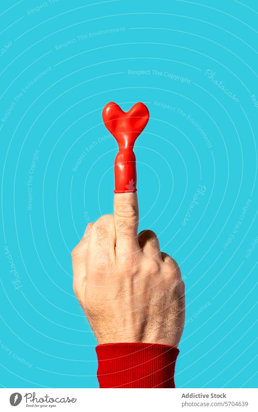 Unrecognizable person middle finger with heart shaped balloon hand festive gesture symbol love vivid sleeve occasion saint valentine day red light fun sweater
