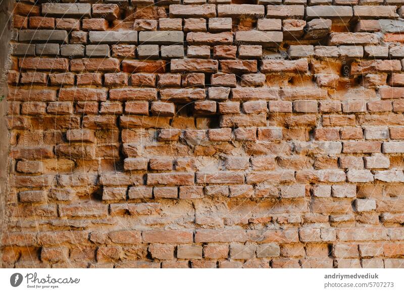 Old red brick wall. Brickwork from an old brick in a rustic style. Structure and pattern of the destroyed stone wall. Industrial exterior brick wall texture background