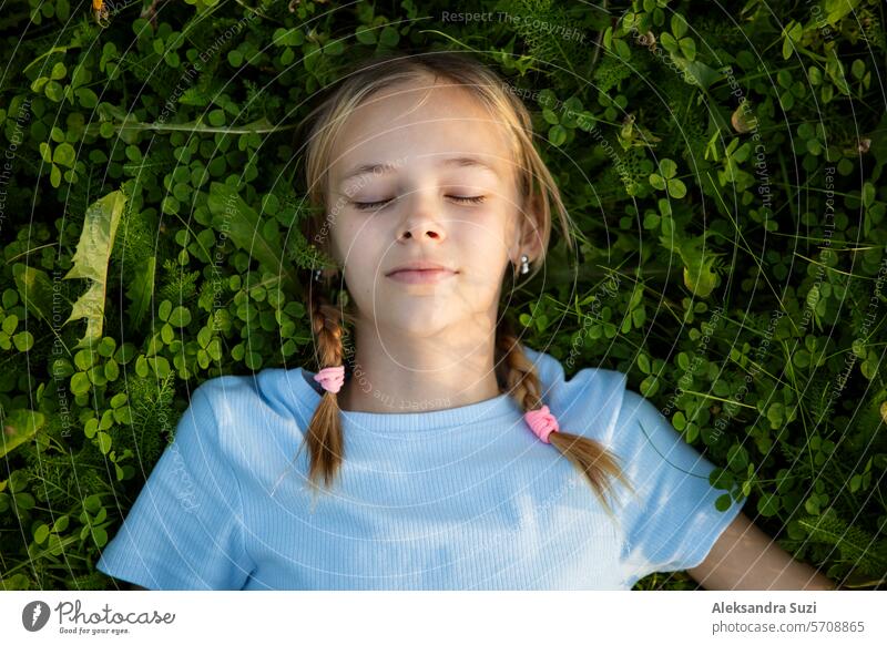 Portrait of a teenage girl lying on the grass. attractive beautiful book casual child cute education enjoyment female field freedom green happy knowledge learn