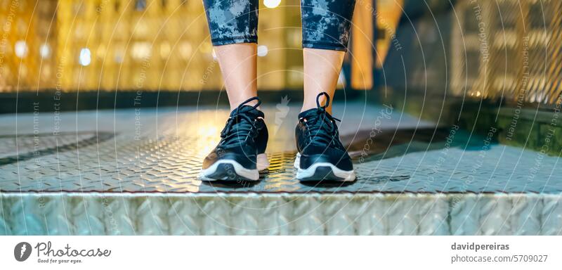 Banner of unrecognizable female athlete legs wearing leggings and sneakers ready to night run feet sportive woman runner standing staircase step evening