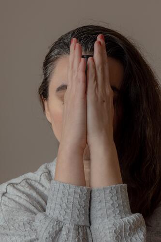 Hands in front of the face indoors dark hair middle age eyes closed Woman Human being ying yang dark light pray Peaceful Think think Distress