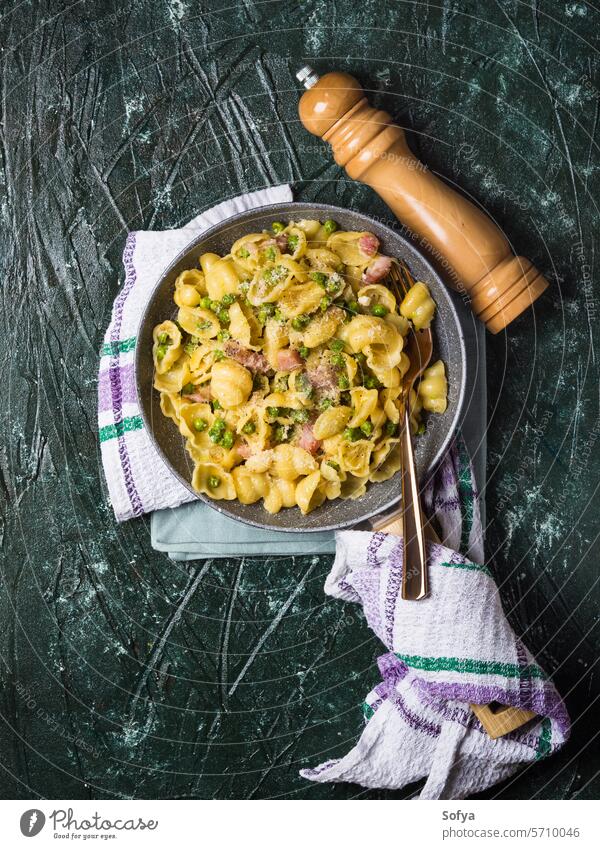 Orecchiette pasta with peas and bacon vegetable green mediterranean macaroni orecchiette cheese rustic cream parmesan lunch dinner flat lay recipe ingredient