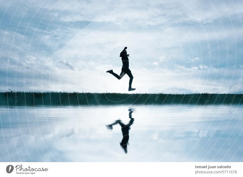 man jumping and reflecting on the lake in the countryside person one person happy happiness enjoy freedom fun vacation puddle pond water ground land reflected