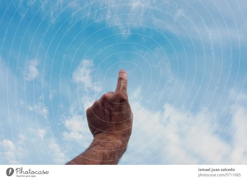 man hand gesturing and pointing at the blue sky arm fingers skin palm palm of hand body part hand up hand raised arm raised touching feeling reaching gesture