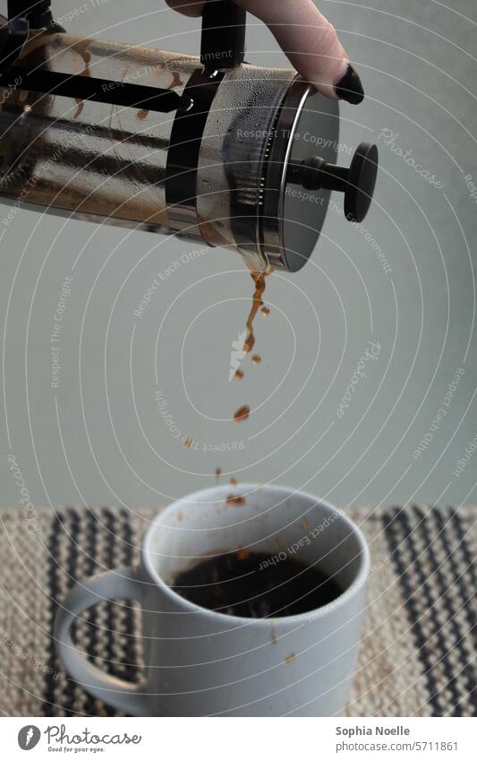 Pouring coffee from a french press into a white cup, in front of a glass background and a stripped placemat Coffee cup Breakfast Coffee break To have a coffee