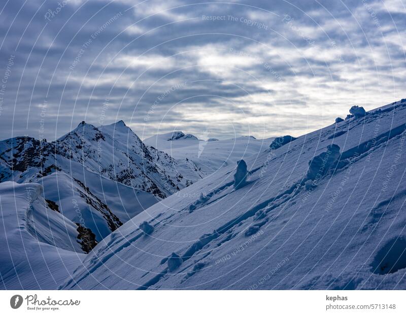 Snow-covered mountain landscape under an almost closed cloud cover Mountain Swiss Alps mountains Winter Switzerland Clouds Winter vacation Snowcapped peak