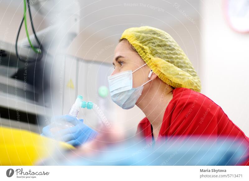 Female anesthesiologist injects anesthesia into patient face mask. General sedation while surgery operation. Paramedic putting oxygen mask for breathing and ventilation of person during resuscitation